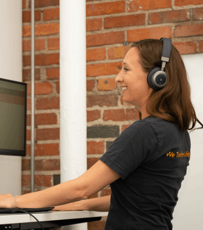 A Prescribe FIT care coordinator talks to a patient on the phone while using her stand up desk