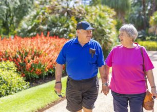 Active Senior Couple Walking in a Park Holding Hands